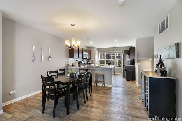 dining space featuring visible vents, wood finished floors, recessed lighting, baseboards, and a chandelier