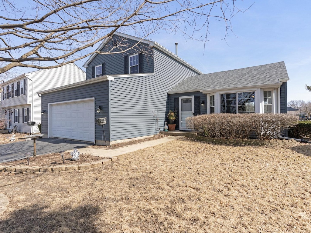 view of front of property with aphalt driveway and a garage