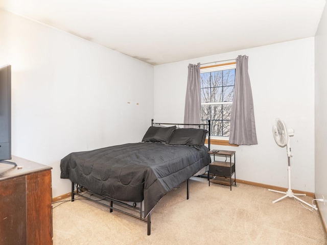 bedroom with baseboards and light carpet