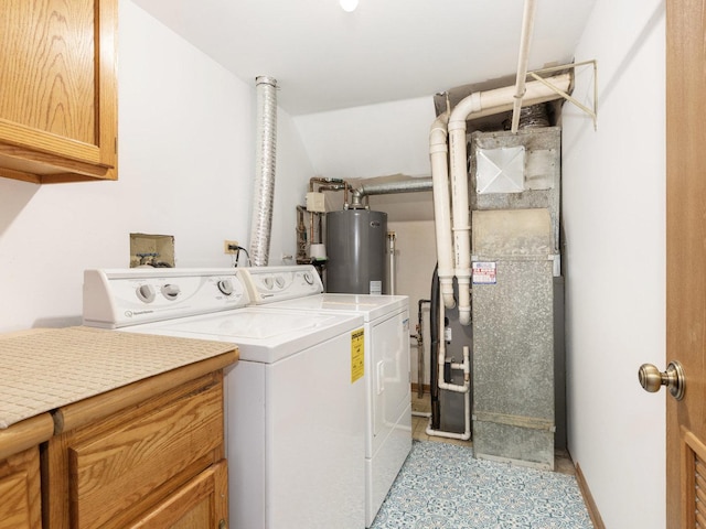 washroom featuring cabinet space, heating unit, gas water heater, and separate washer and dryer