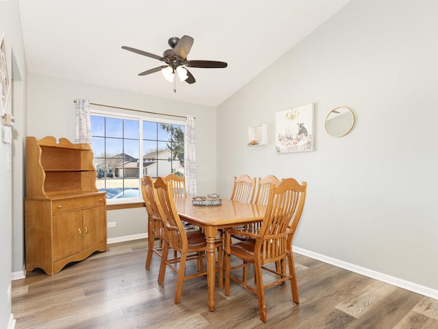 dining area featuring lofted ceiling, light wood-style floors, and baseboards