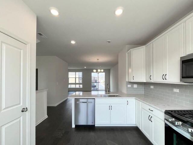 unfurnished dining area featuring dark wood-style floors, a notable chandelier, and baseboards