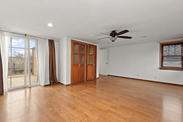 spare room with recessed lighting, light wood-style flooring, a ceiling fan, and baseboards