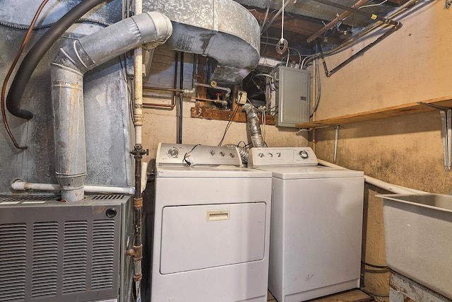 laundry area featuring electric panel, washing machine and dryer, laundry area, and a sink