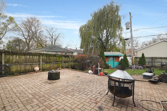 view of patio / terrace with an outbuilding, a fenced backyard, and outdoor dining space