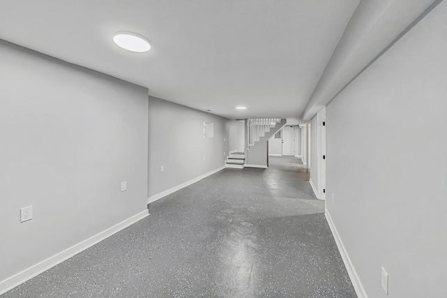 finished basement featuring stairs and baseboards