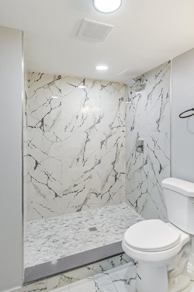 bathroom featuring toilet, marble finish floor, visible vents, and a marble finish shower