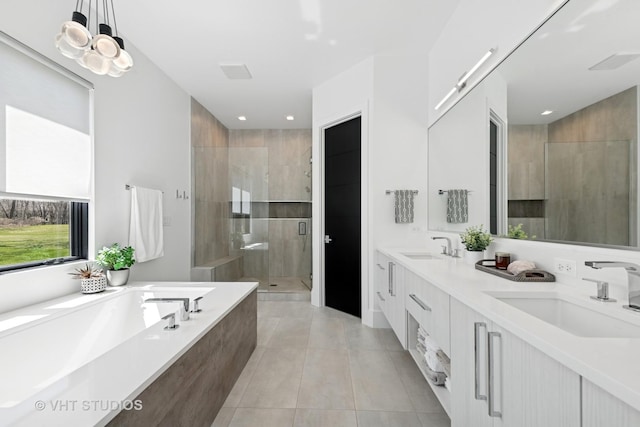 bathroom featuring a shower stall, tile patterned flooring, a garden tub, and a sink