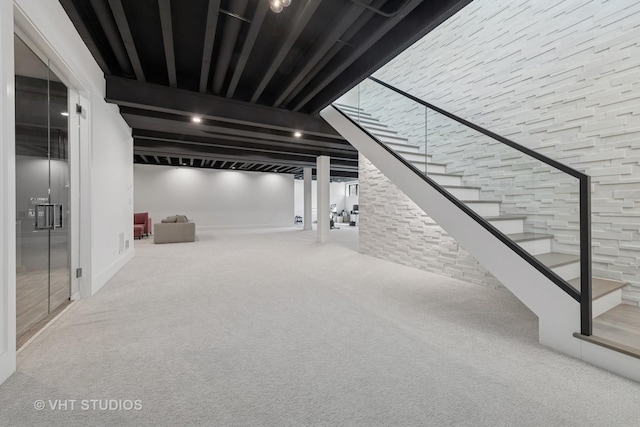 finished basement featuring stairway and carpet flooring