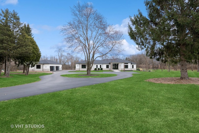 ranch-style home featuring a front yard, a garage, and driveway