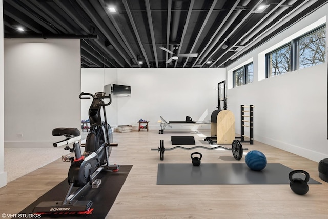 exercise area with wood finished floors and baseboards
