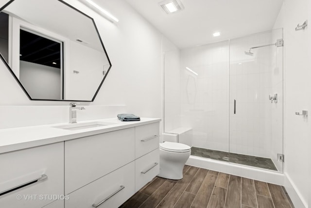 full bathroom featuring vanity, a stall shower, toilet, and wood finished floors