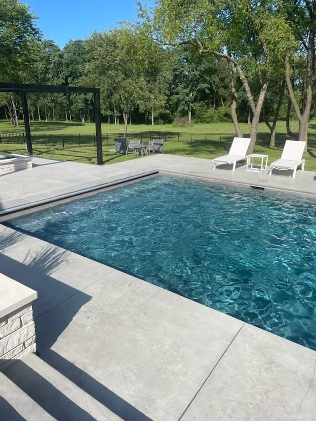pool featuring a patio area, fence, and a yard