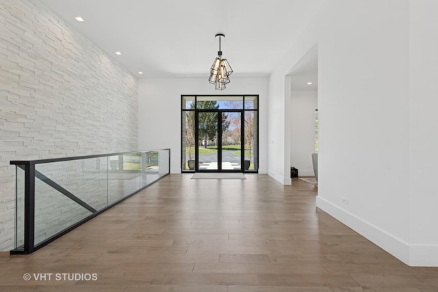 unfurnished dining area with wood finished floors, baseboards, and recessed lighting
