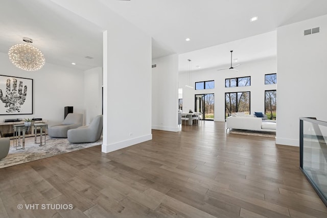 living room featuring visible vents, baseboards, recessed lighting, wood finished floors, and ceiling fan with notable chandelier