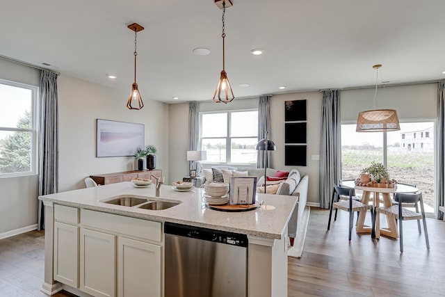 kitchen featuring a sink, stainless steel dishwasher, white cabinets, and light wood finished floors