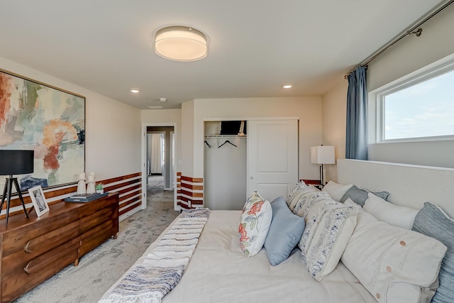 bedroom with a closet, recessed lighting, and carpet