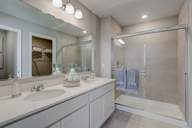 bathroom with tile patterned flooring, visible vents, a stall shower, and a sink