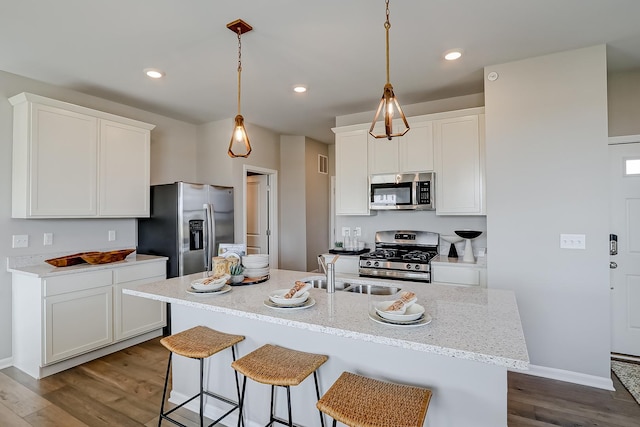 kitchen featuring a sink, dark wood-type flooring, a kitchen breakfast bar, and stainless steel appliances