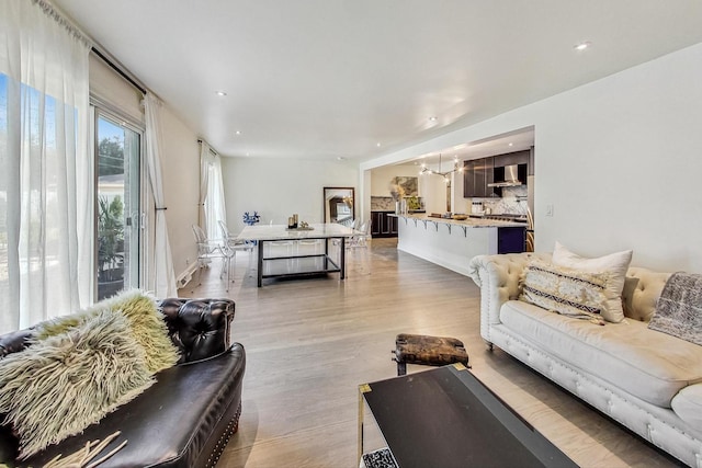 living area with recessed lighting, baseboards, and light wood finished floors