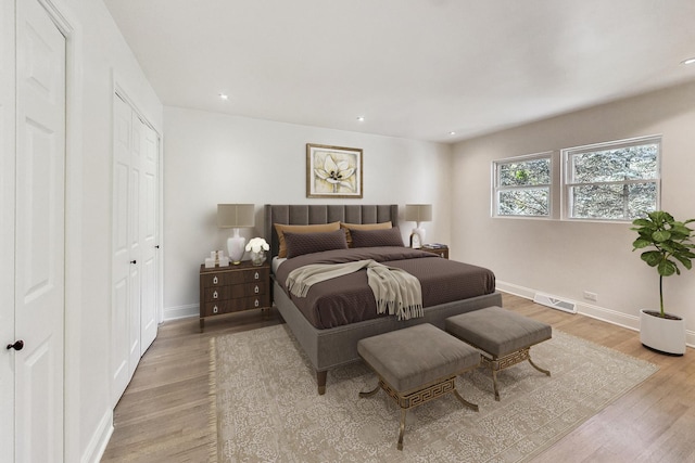 bedroom with light wood-style flooring, recessed lighting, baseboards, and visible vents