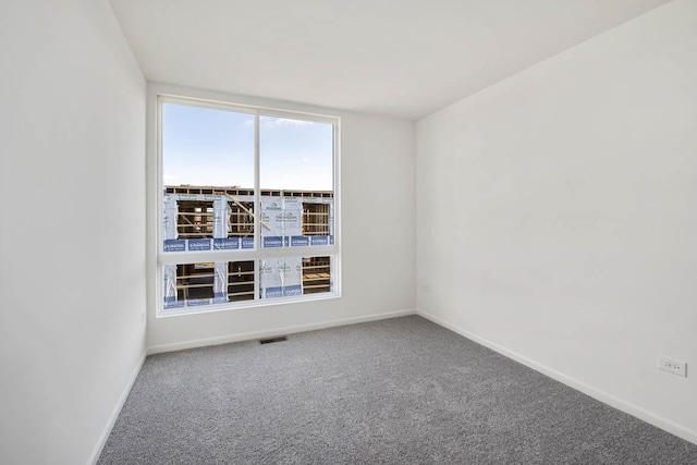 empty room with visible vents, baseboards, and carpet floors