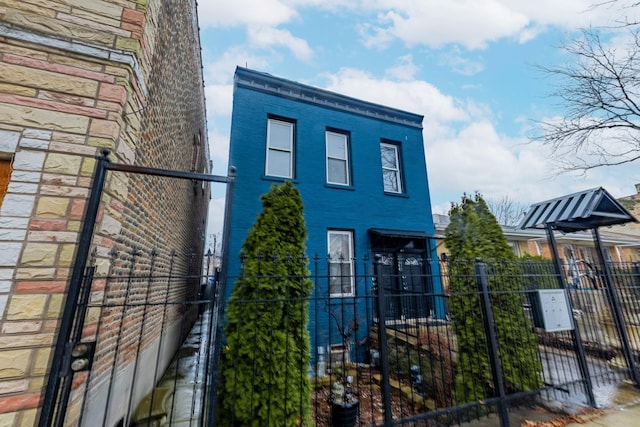 view of home's exterior with a gate, fence, and brick siding