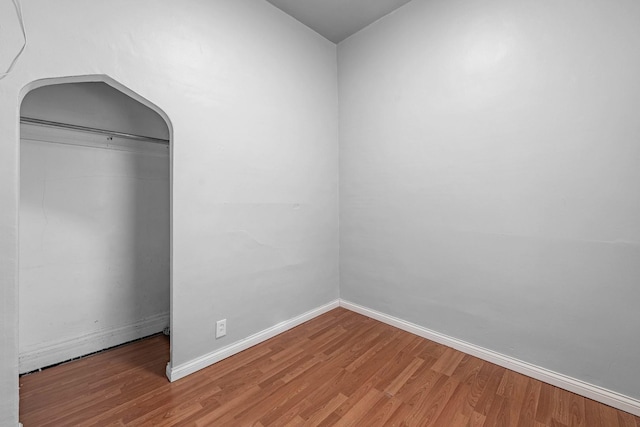 unfurnished room featuring baseboards and wood finished floors