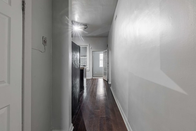 corridor featuring dark wood finished floors and baseboards