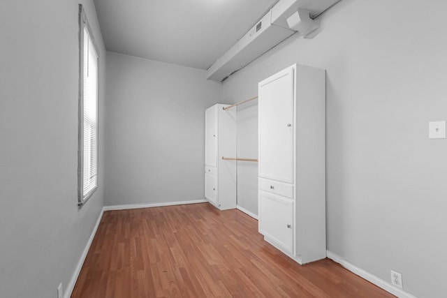 spare room with light wood-style flooring and baseboards