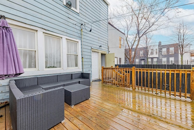 wooden terrace with an outdoor living space and fence