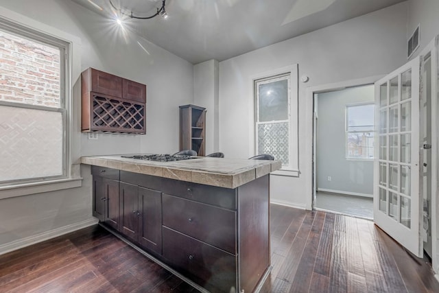 kitchen featuring visible vents, baseboards, a peninsula, and dark wood-style floors