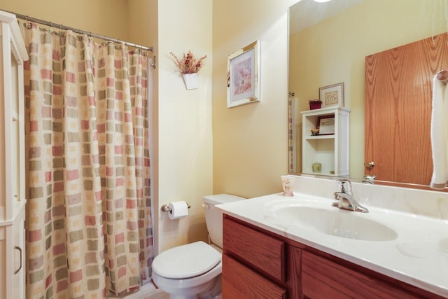 bathroom featuring a shower with shower curtain, toilet, and vanity