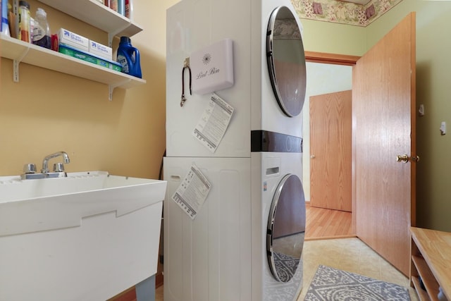 washroom with laundry area, light tile patterned flooring, and stacked washer / drying machine