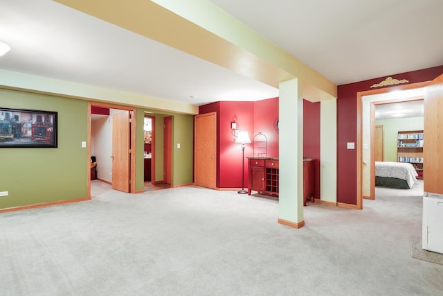 interior space featuring light colored carpet and baseboards