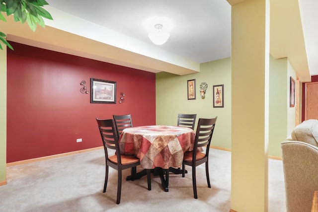 dining room featuring light carpet and baseboards