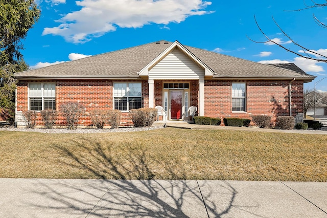 ranch-style home with brick siding, a shingled roof, and a front yard