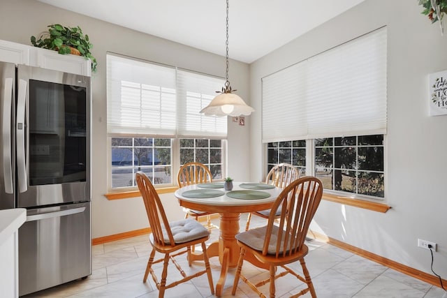 dining space featuring baseboards and marble finish floor