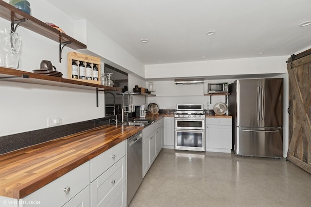 41660 N Hunt Club Rd, Old Mill Creek, IL 60083 - kitchen featuring white cabinetry, open shelves, a barn door, butcher block counters, and appliances with stainless steel finishes