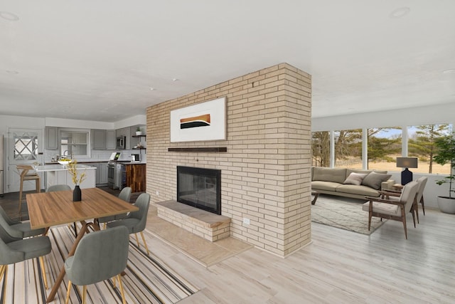 41660 N Hunt Club Rd, Old Mill Creek, IL 60083 - dining area with light wood-style floors and a brick fireplace