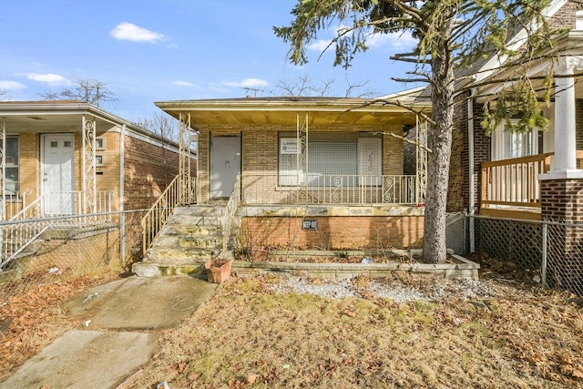 view of front facade with brick siding and covered porch