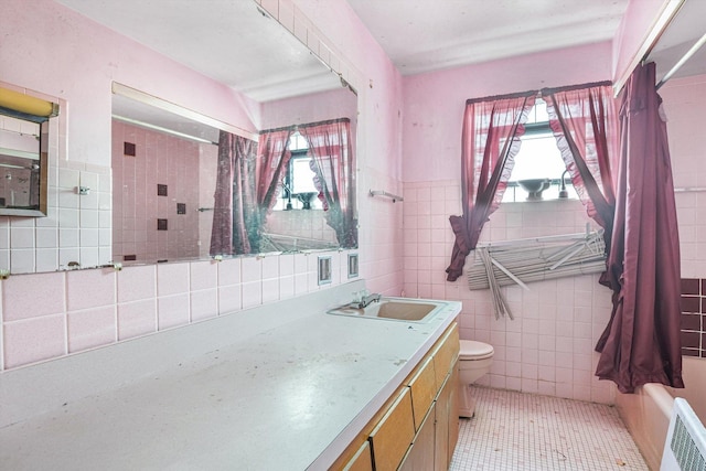 full bathroom with vanity, radiator, tile patterned flooring, tile walls, and toilet