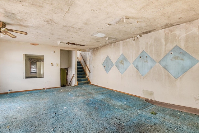 carpeted spare room with baseboards and stairs