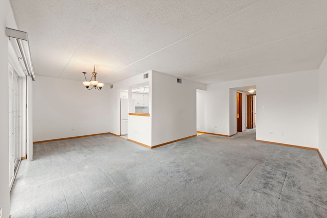 unfurnished living room with a textured ceiling, visible vents, baseboards, light carpet, and a notable chandelier