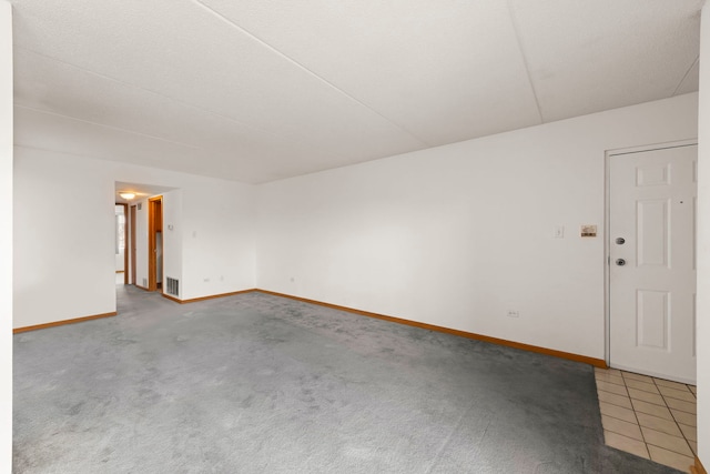 empty room featuring visible vents, carpet flooring, and baseboards