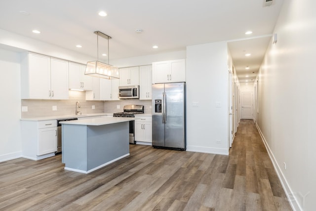 kitchen featuring a sink, light countertops, white cabinets, appliances with stainless steel finishes, and tasteful backsplash