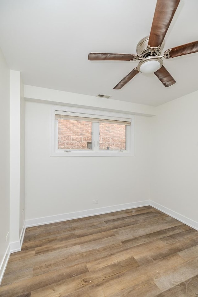 spare room with light wood finished floors, visible vents, ceiling fan, and baseboards