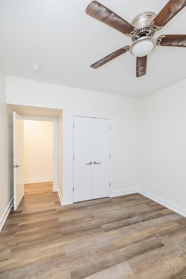 unfurnished room with baseboards, light wood-style flooring, and a ceiling fan