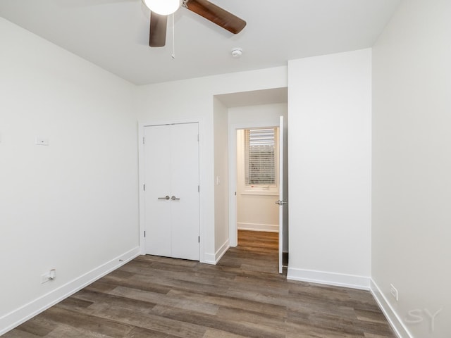 empty room featuring a ceiling fan, baseboards, and wood finished floors