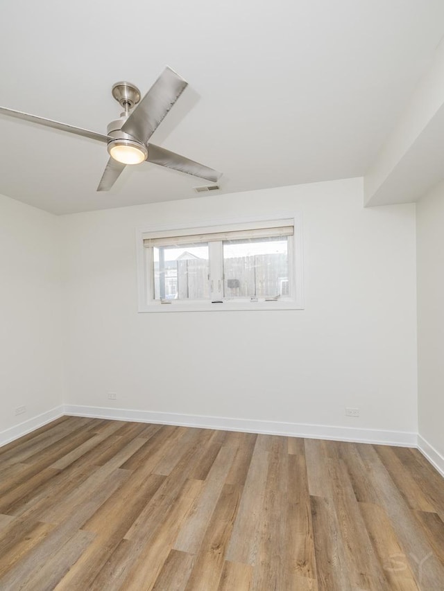 empty room with a ceiling fan, visible vents, light wood-style floors, and baseboards